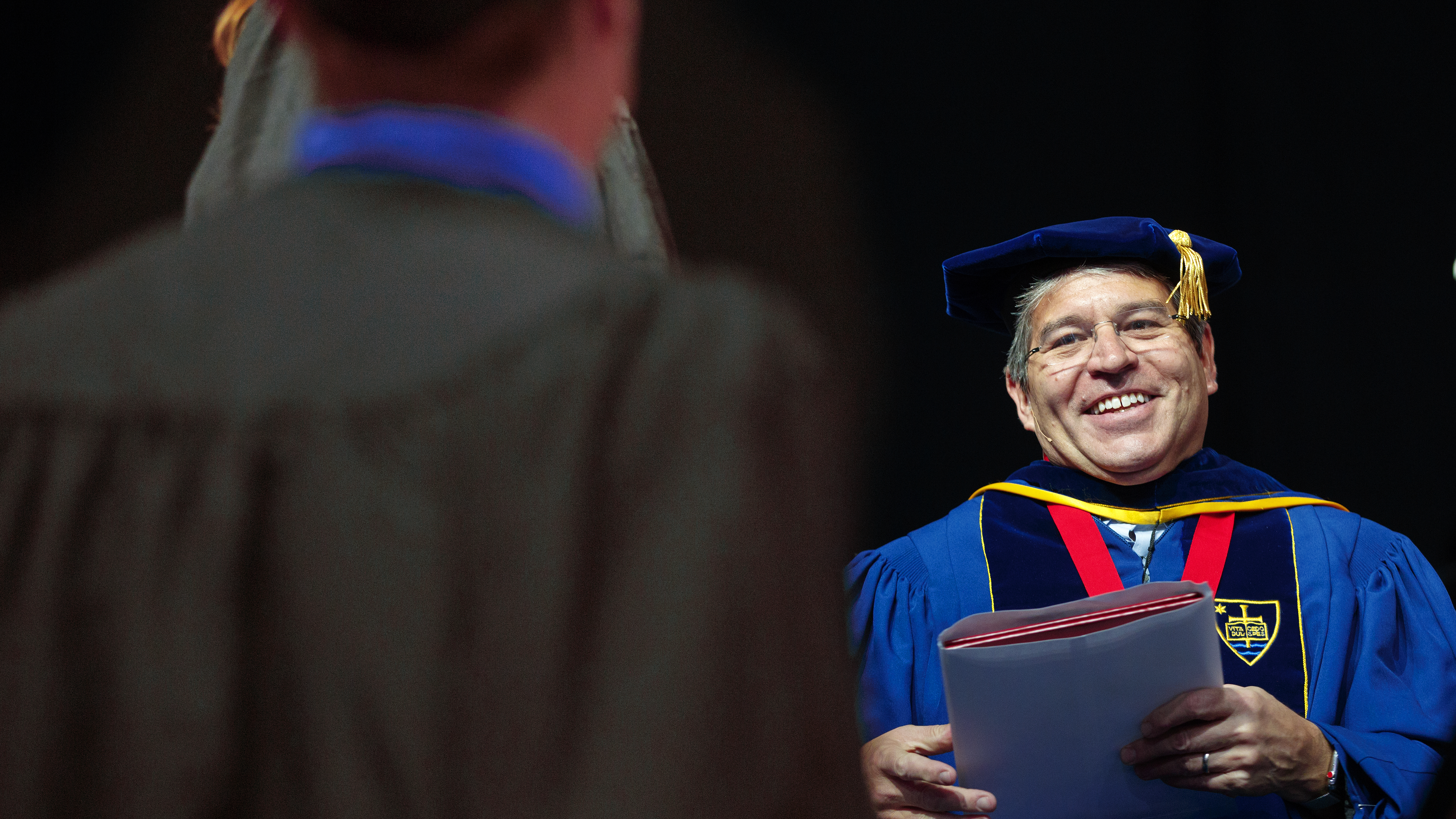 Lance C. Pérez prepares to hand a diploma to a Nebraska Engineering student during the undergraduate commencement ceremony on May 5. Pérez has been named dean of engineering.