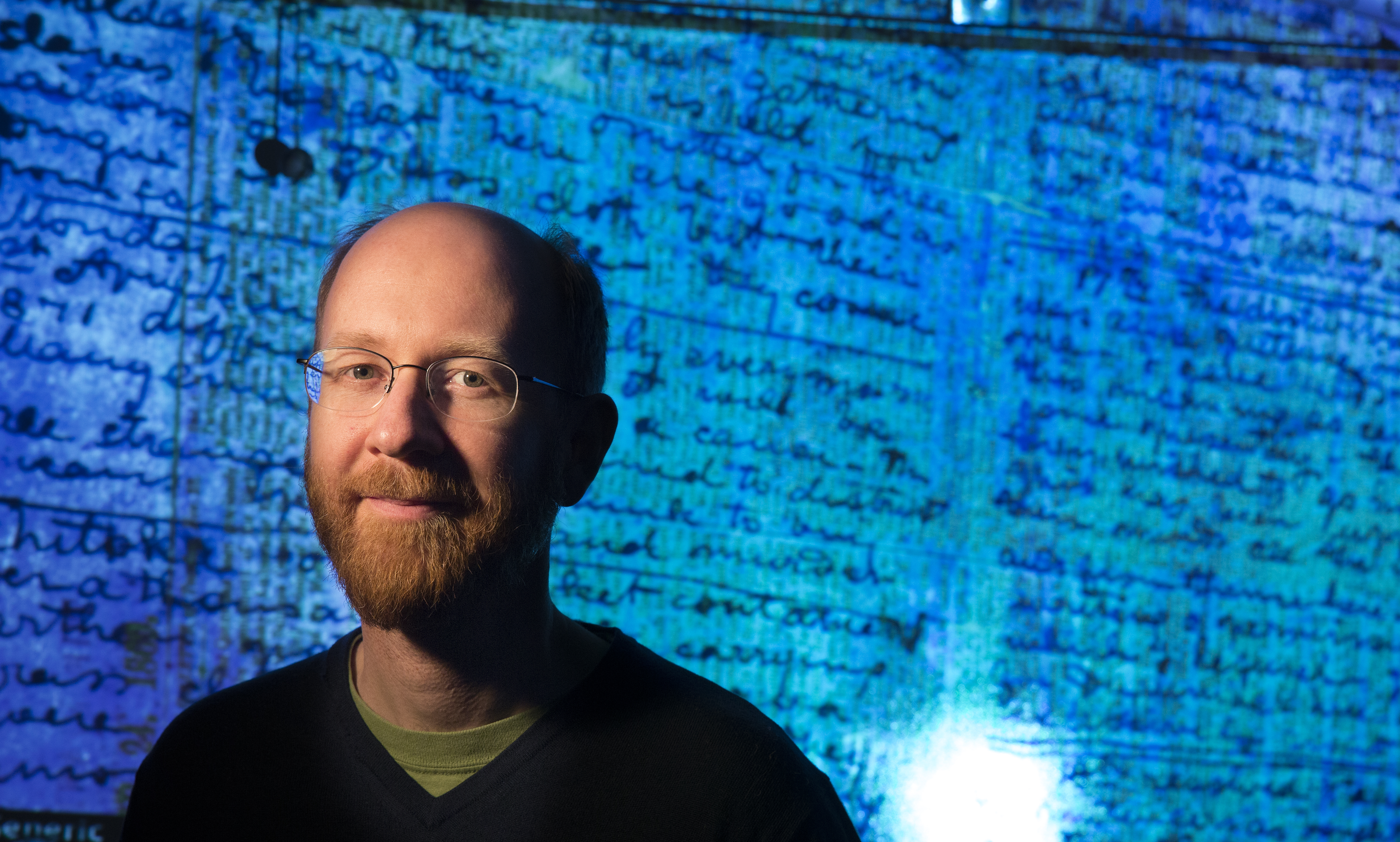 Adrian Wisnicki, assistant professor of English, stands in front of a projected image of David Livingstone's 1871 diaries.