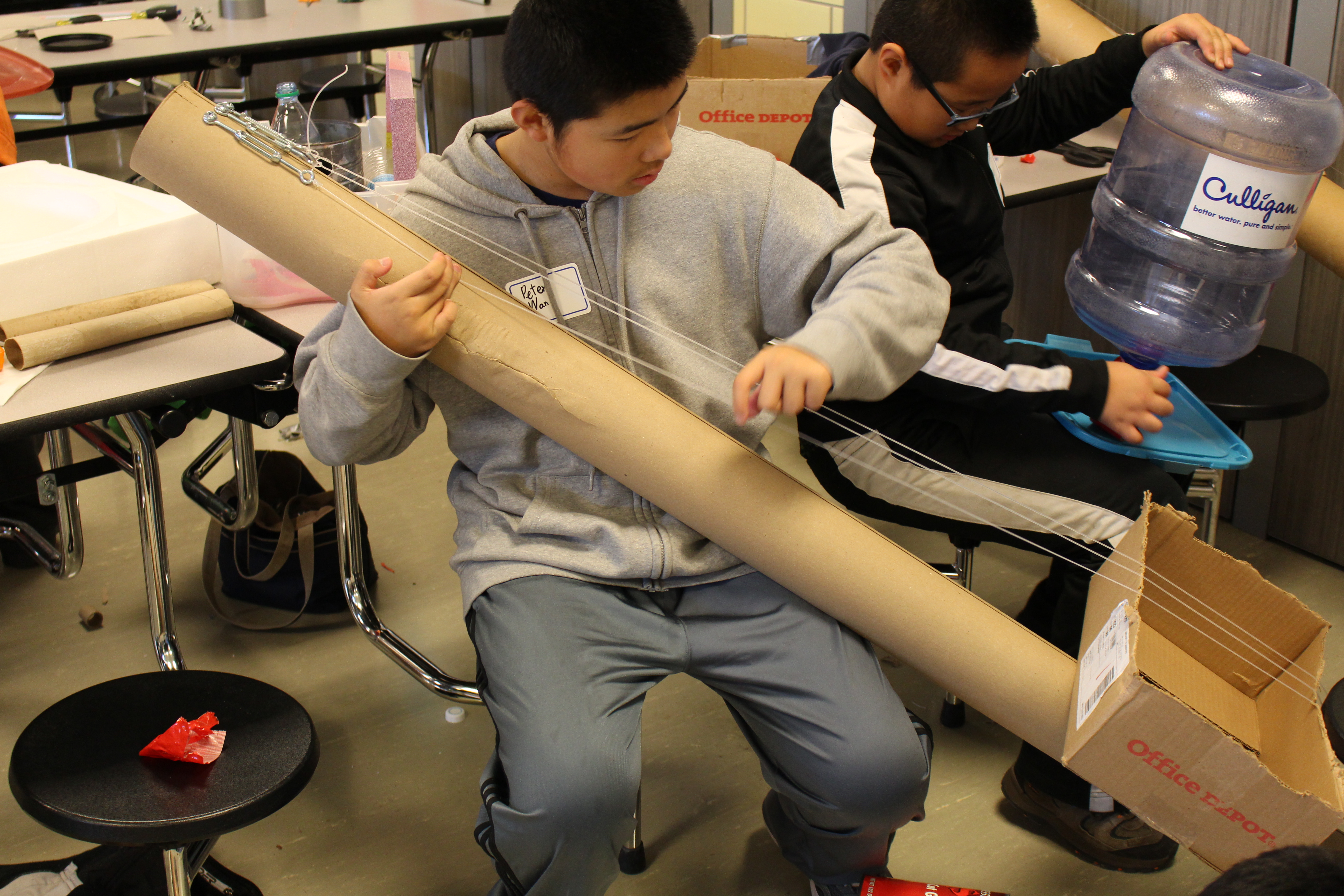 Under the direction of Kennedy Center teaching artist and science educator John Bertles, Science of Sound Spring Break Camp participants experiment with sound on musical instruments created from recycled materials at Dawes Middle School in 2014.