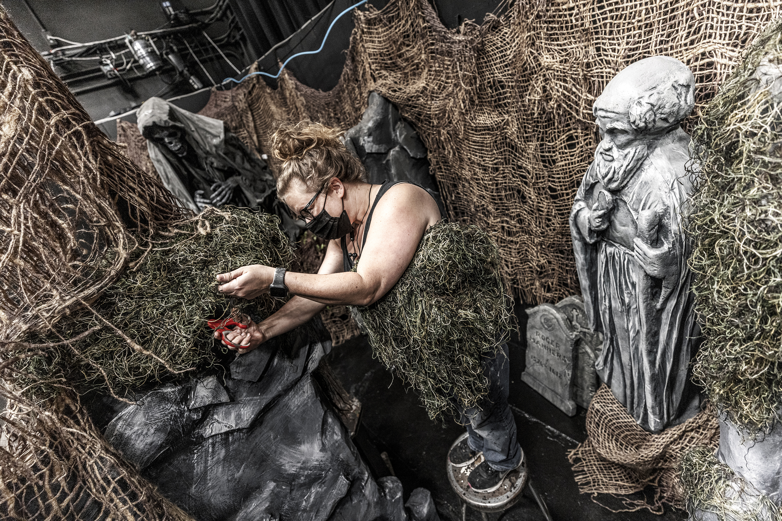 Production designer Jill Hibbard works on the scenery among the statuary.