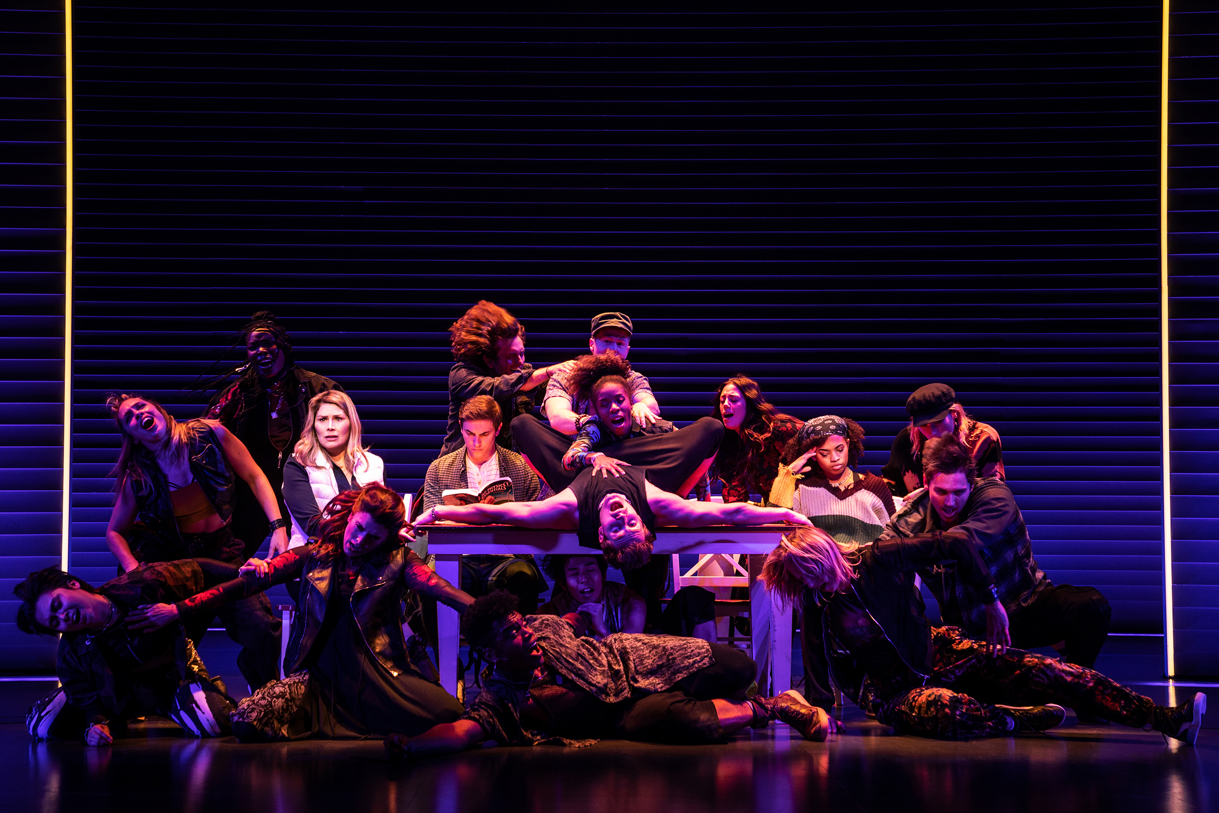Group of performers contorted around table