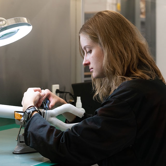 Husker engineering graduate student Rachael Wagner adjusts the MIRA surgical robot.