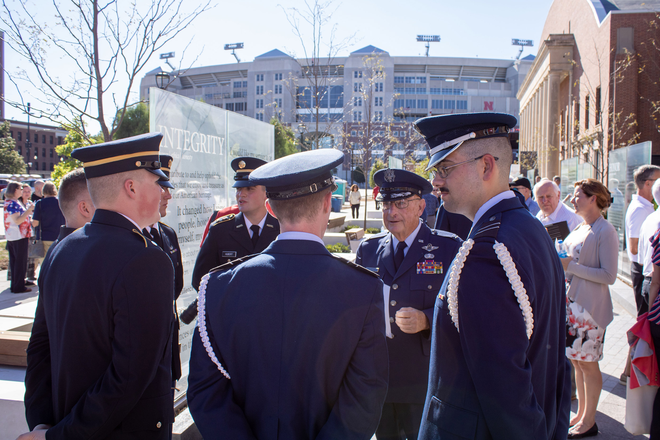 A group of military service members chats near the Veterans' Tribute space