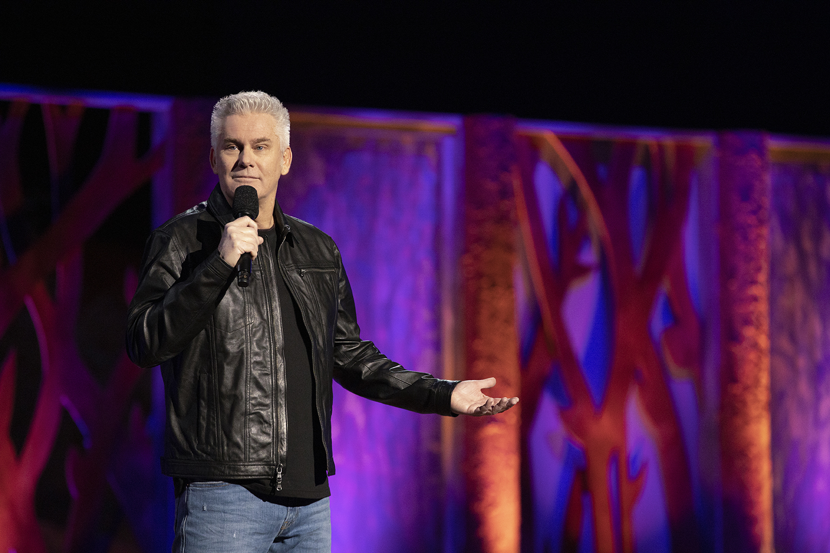 Brian Regan appears onstage, holding a microphone.