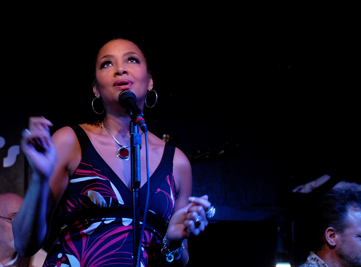 Angela Hagenbach sings into a microphone.