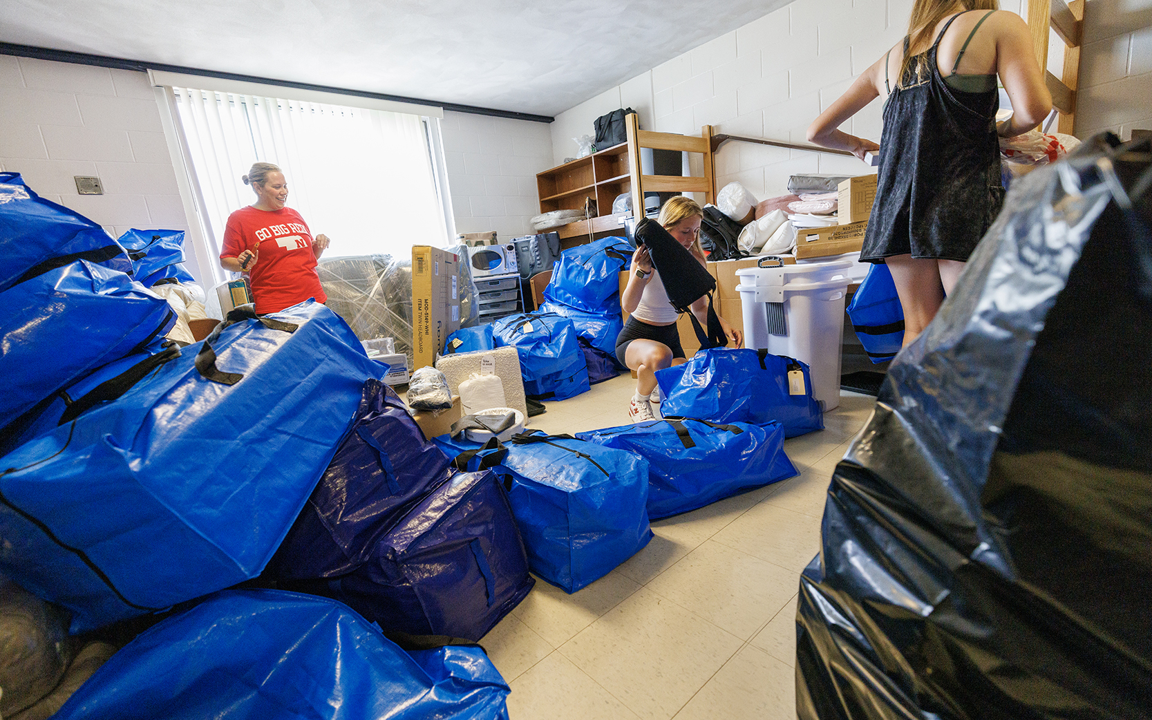 Alyssa Hurlock of Apple Valley, Minnesota, watches as Lily Hurlock unpacks her belongings in the Smith Residence Hall room she shares with her sister, Haven. The two are sharing a room, while their triplet sister Montanna has a room on another floor in the hall.