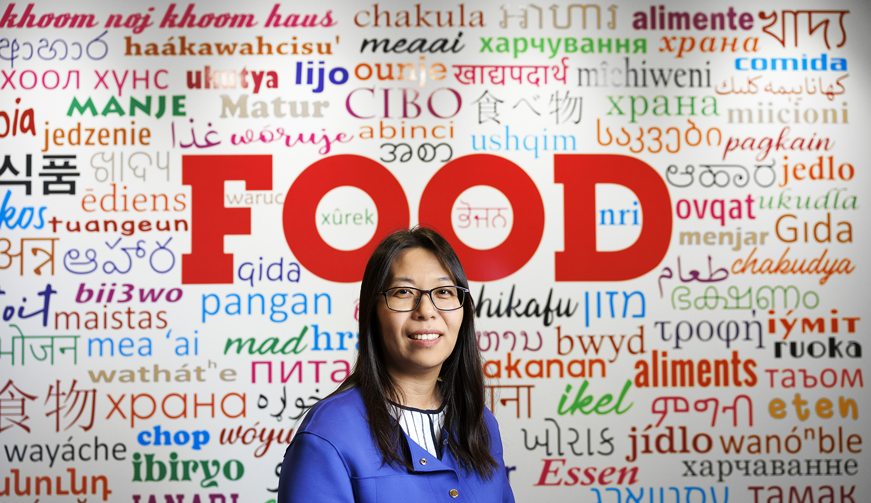 Bing Wang, in front of a wall with words in numerous languages