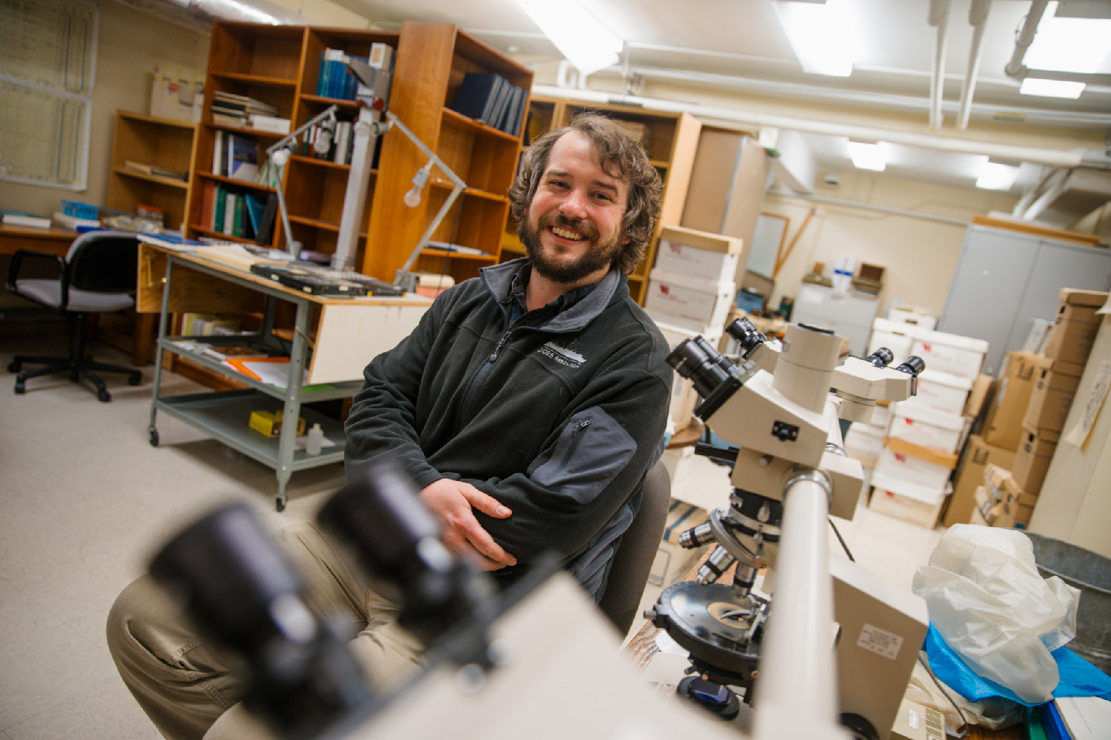 Postdoctoral researcher Jason Coenen sits near microscopes in a University of Nebraska–Lincoln lab.