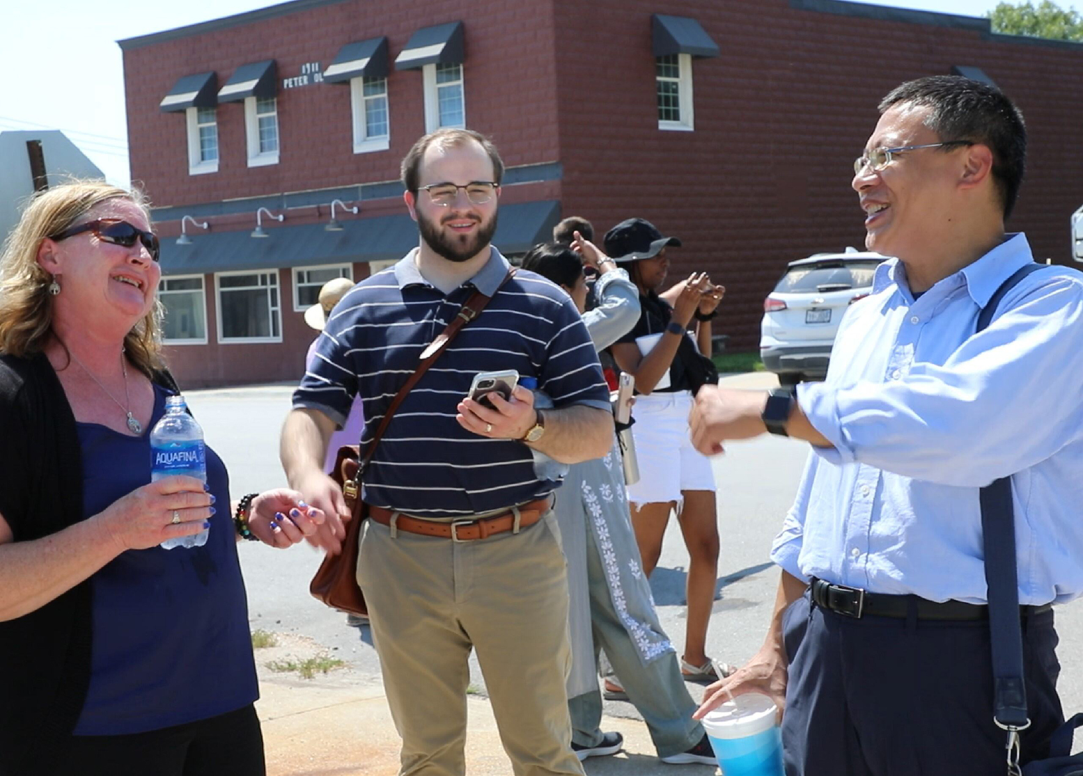 Zhenghong Tang, professor and director of the Community and Regional Planning Program at Nebraska, talks with a man and woman.