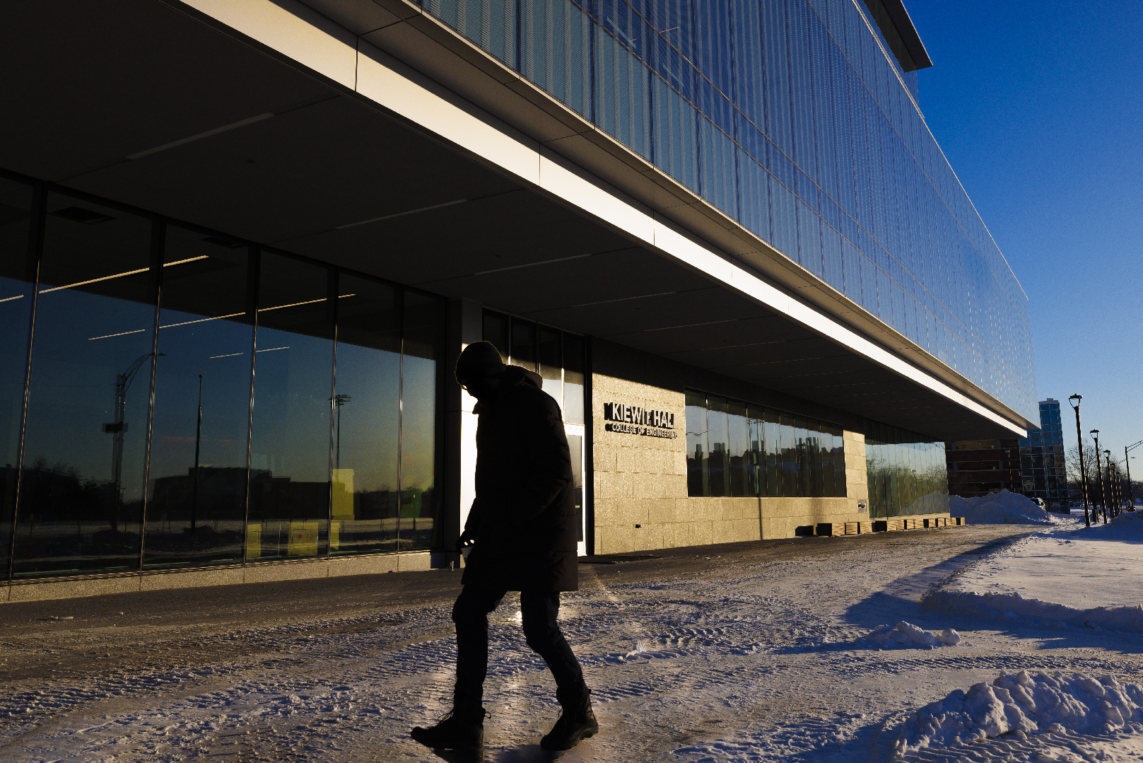 A man walks toward the south entrance of Kiewit Hall.