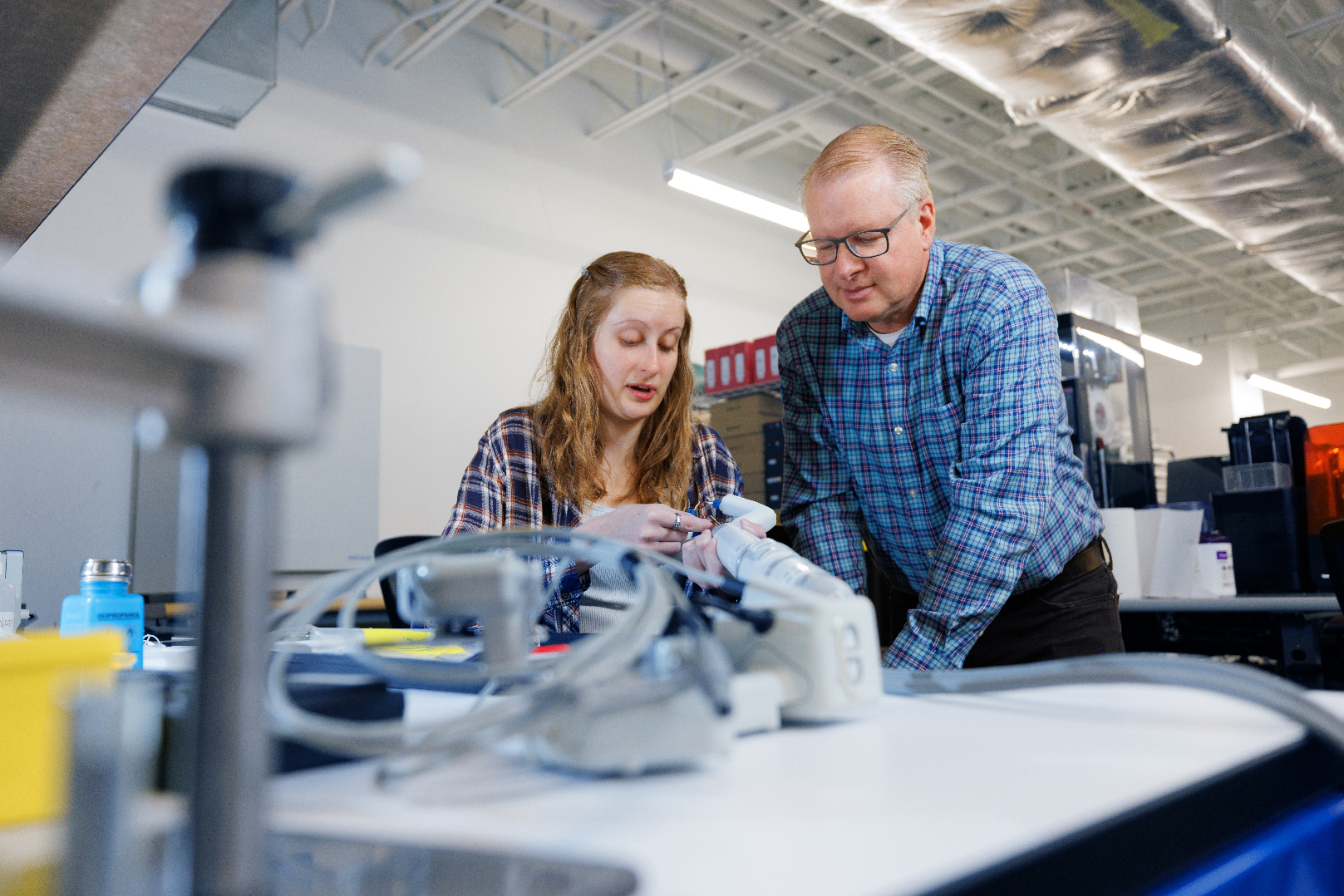 Rachael Wagner and Shane Farritor look over a robotic surgery device in the Virtual Incision facility.