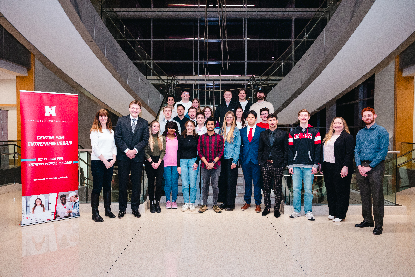 About 20 students pose for a photograph on the main staircase of Howard L. Hawks Hall.