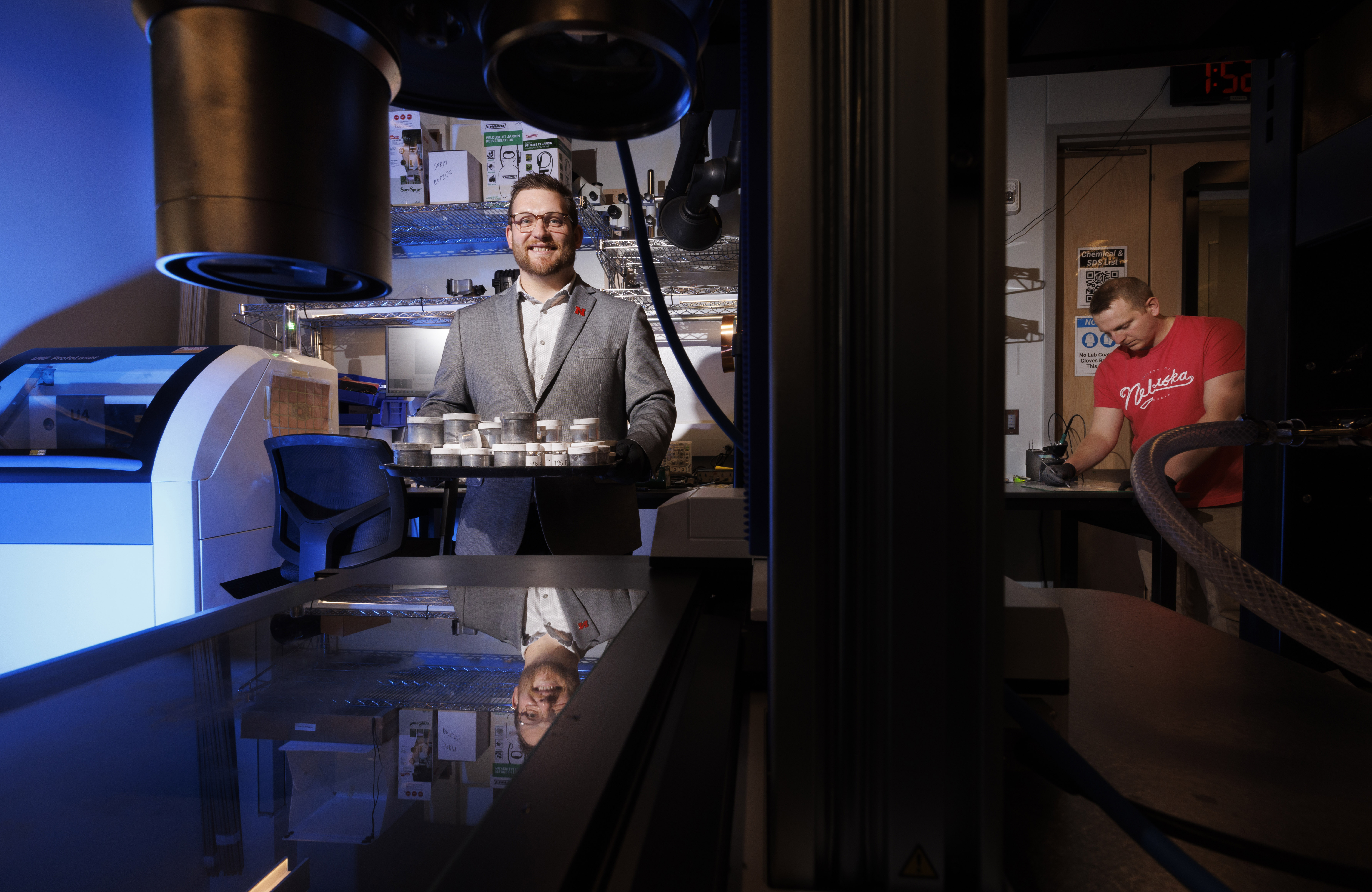 Eric Markvicka (left), assistant professor of mechanical and materials engineering, holds a tray of liquid metal samples while graduate student Ethan Krings works on a sample at right.