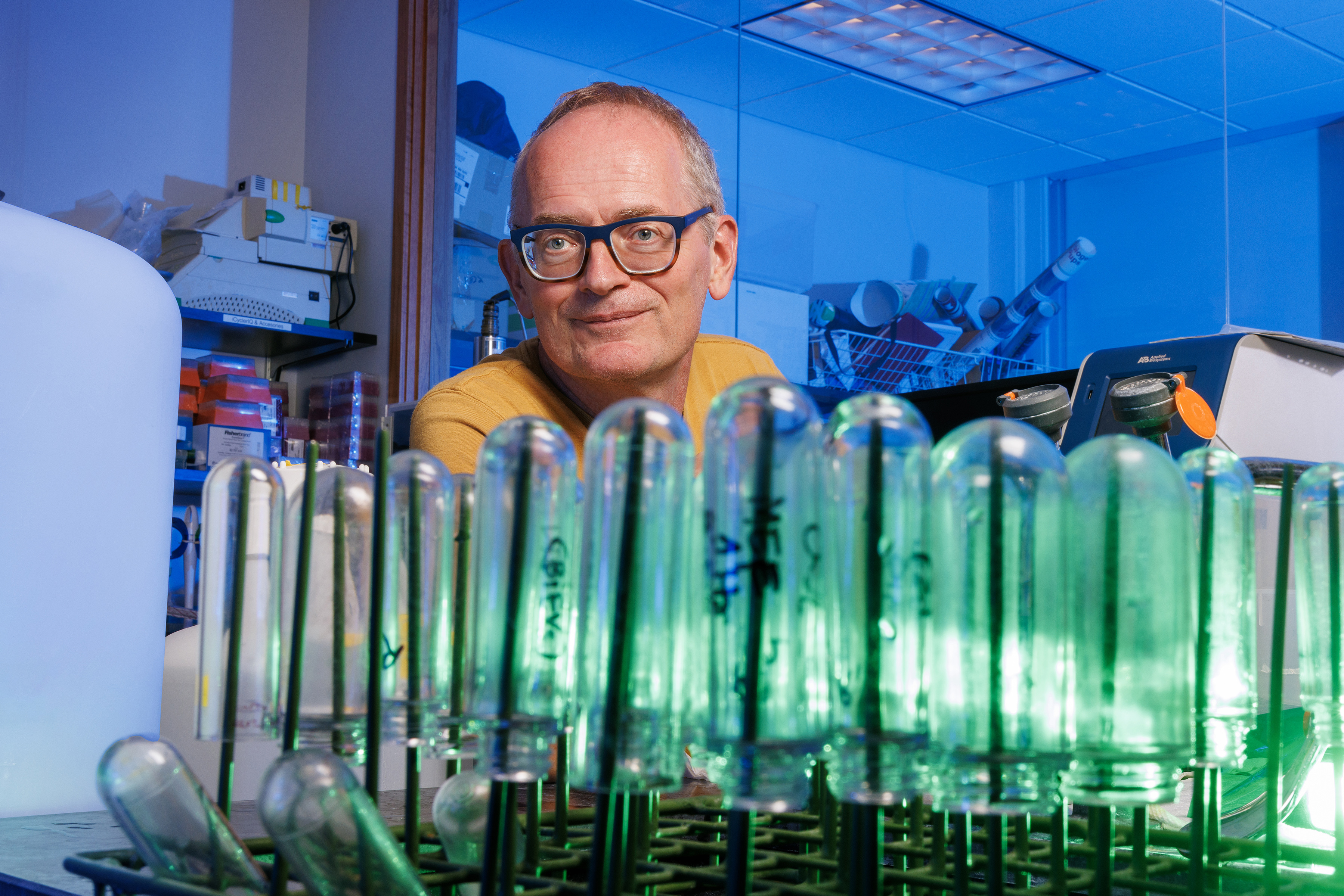 Janos Zempleni peers over upside-down test tubes in a lab.