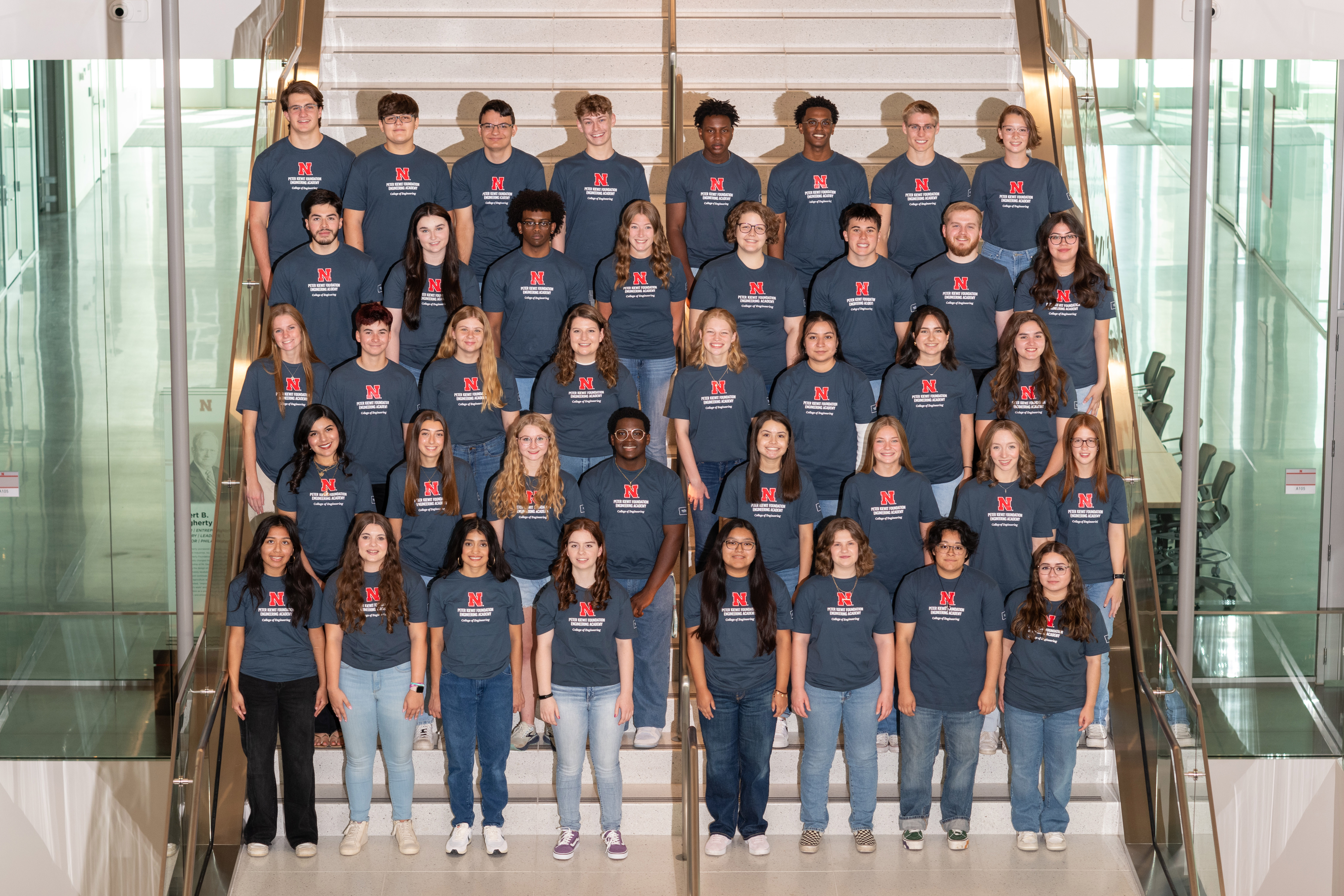 Forty first-year students, all members of the 2024-25 cohort of the Peter Kiewit Foundation Engineering Academy, pose on a staircase in five rows of eight people each.