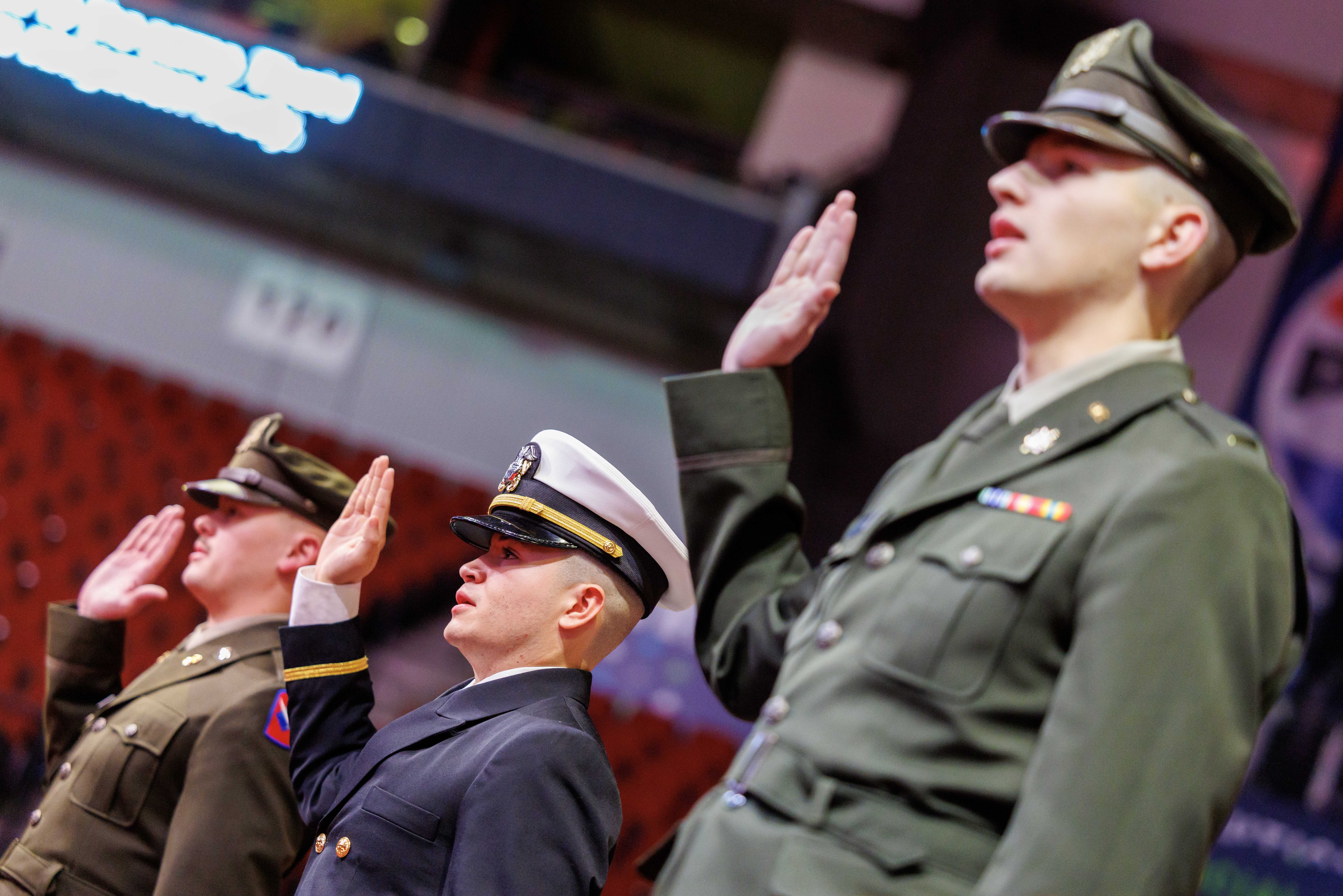 Three male members of the University of Nebraska–Lincoln's Reserve Officer Training Corps, in uniform, recite the oath of enlistment during the undergraduate commencement ceremony Dec. 21 at Pinnacle Bank Arena.