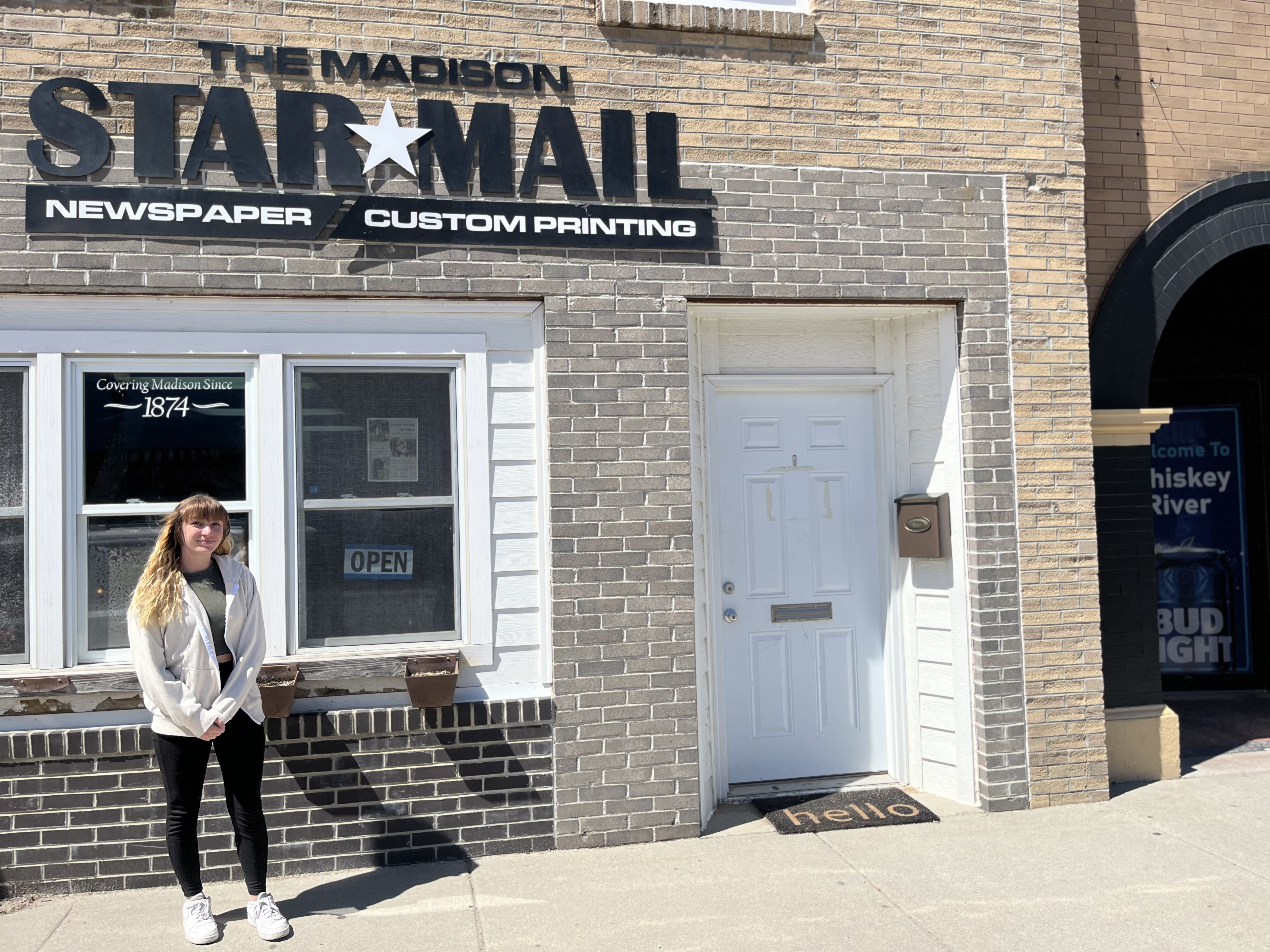 Alana Kellen, owner, editor and publisher of the Madison Star-Mail, stands in front of the brick building that houses the paper. 