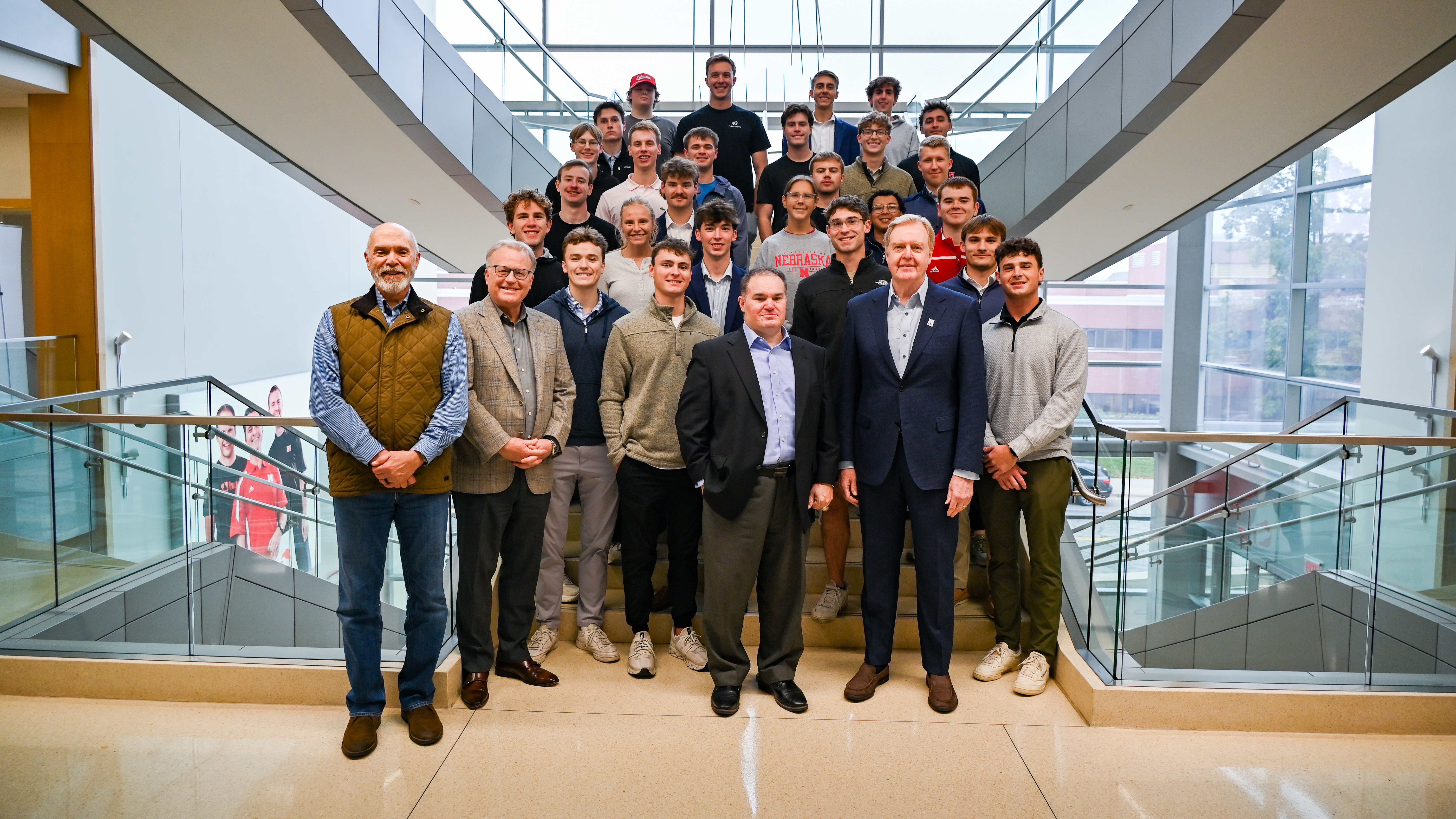 A group of 30 people — mostly University of Nebraska–Lincoln students in the Investors With Purpose program — pose for a photo on a staircase in Howard L. Hawks Hall.