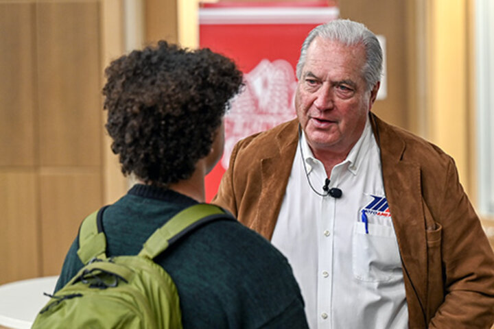 Richard Varner, chief financial officer of MotoAmerica and a Husker alumnus, talks with a male student.