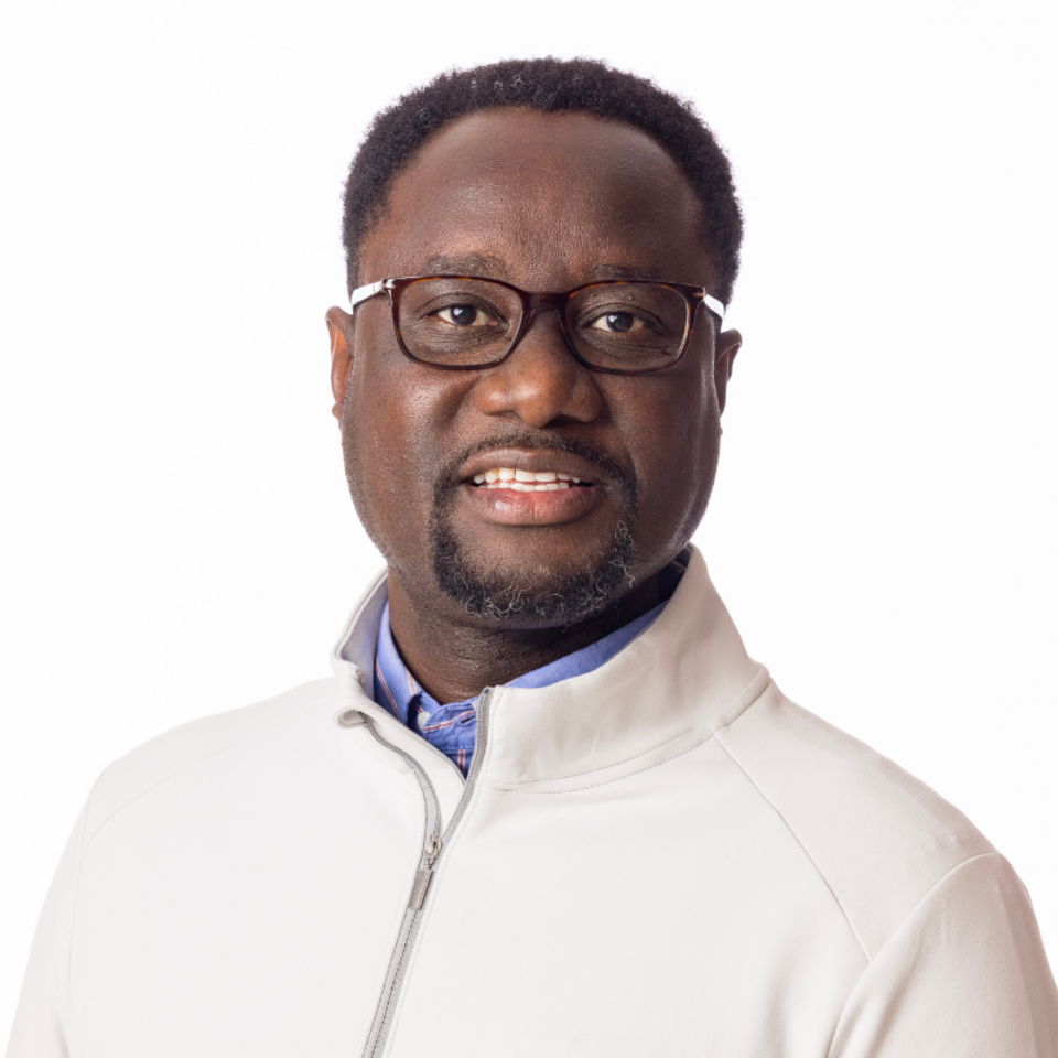 Color portrait of Dane Kiambi, associate professor of advertising and public relations at the University of Nebraska– Lincoln, wearing a white jacket and glasses.