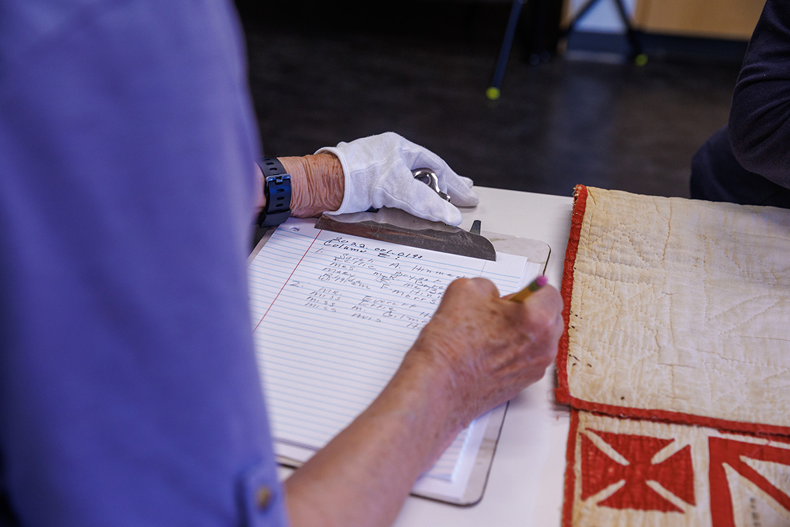 Susan Macy writes down the names off the quilt according to the column where they were located.