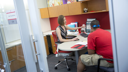 A student talks with Jaci Gustafson in the University of Nebraska–Lincoln's Explore Center. The University Registrar is adjusting services to further support student success. The changes include expanding services to faculty and staff.