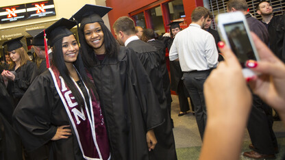 Lizzette Osorio (left) and Lea Henry pose for a photo before UNL commencement at Pinnacle Bank Arena on Dec. 21, 2013. A report issued by the Education Trust group showed that UNL is a national leader in improving graduation rates for underrepresented students.