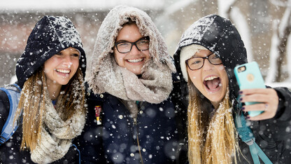 Kayla Felix (from left) and Alli Hauger smile as Emily Hames takes a selfie while they walked to class as snow fell on Jan. 25. 