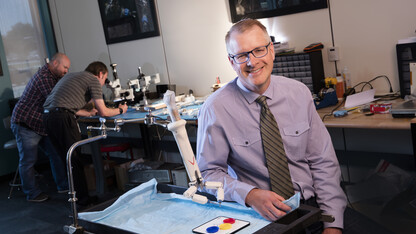Shane Farritor has been named a Fellow of the National Academy of Inventors. He is pictured here with a prototype of one of his advanced miniaturized robots that shows promise for colon resection, a procedure used to treat diverticulitis, large colon polyps, precancerous and cancerous lesions of the colon and inflammatory bowel disease.