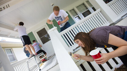 Kate Christensen from Utah works on a porch rail while her husband, L1 law student Theron Christensen works on the porch column at a house on B Street. Students, faculty and staff from the College of Law participated in the city-wide Paint-A-Thon by painting four houses. August 20, 2016.