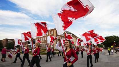 Cornhusker Marching Band flags fly along R Street during the 2016 homecoming parade