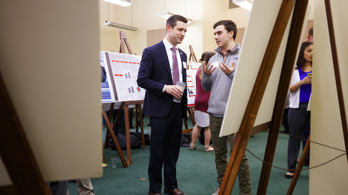 Sen. Adam Morfeld listens as Michael True discusses his research, "Species Richness, Relative Abundance, and Disease Exposure in Small Mammals."