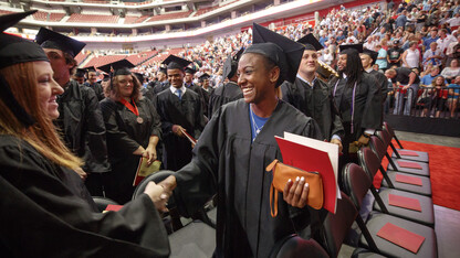 Kristen Dowell, a hurdler with Husker track and field and hospitality, restaurant and tourism management major, shakes hands with a fellow graduate during summer 2018 commencement exercises in Pinnacle Bank Arena.