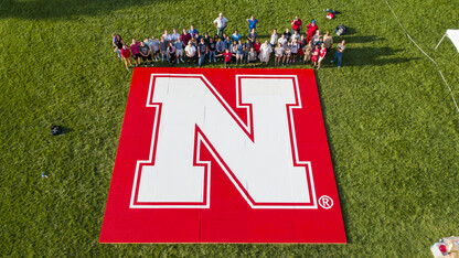 Volunteers pose with Nebraska's John Lang after breaking the Guinness World Record for largest mosaic built with tiny plastic bricks. This is the second world record set by Lang in as many years.