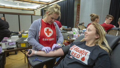 Samantha Severin smiles as American Red Cross worker Lisa Koziel finishes placing a needle as part of the homecoming blood drive on Sept. 25. The student-led drive is the largest annual collection in Nebraska.