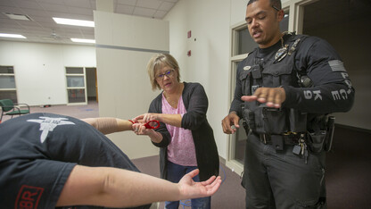 K-9 Officer Russell Johnson Jr. (right) shows Julie Thomsen how to apply handcuffs during the second week of the University Police Department's Citizens' Police Academy. The six-week program is designed to educate members of the campus community about the University Police Department.