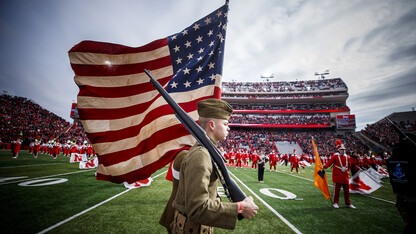 Dressed in World War I uniforms, ROTC students carry a flag into Memorial Stadium prior to the Nov. 10 football game with Illinois.