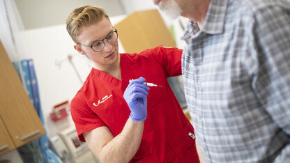 Josh Gasper, a senior nursing student, gives a flu shot in the University Health Center in this file photo from 2019. While it's not effective against COVID-19, the CDC continues to recommend that individuals get the flu vaccine as seasonal influenza activity remains high. The vaccine helps individuals prevent influenza and possible unnecessary evaluations for COVID-19. Learn more about getting the vaccine at https://health.unl.edu.