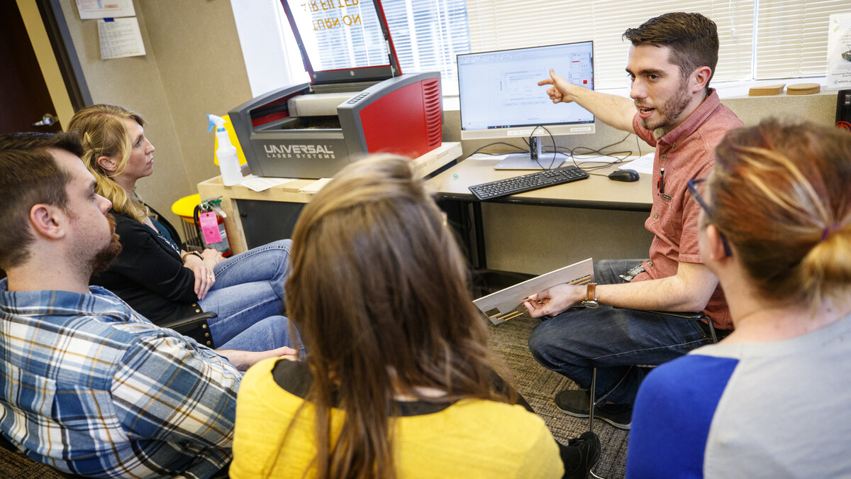 Max Wheeler (pointing to computer screen), NIS instructional designer, leads a training for Library Innovation Studios May 22.