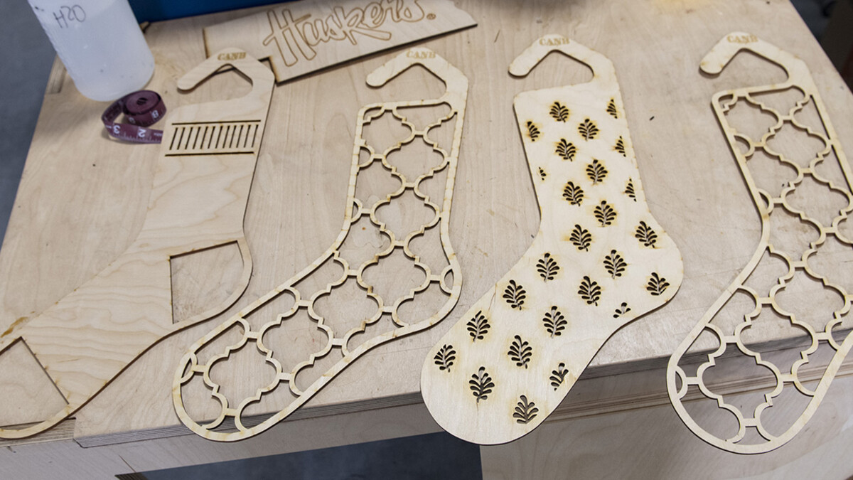 Carly Brotherson pulls sock blocks from the laser cutter at Nebraska Innovation Studio Nov. 25. Brotherson made the sock blocks for a yarn store, which requested the project through the new 'Request a Maker' button, which matches makers to projects. November 25, 2019.