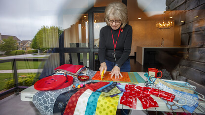 Joy Shalla Glenn, a public programs and membership assistant with the International Quilt Museum, cuts fabric for masks in her living room. She is among the more than 70 individuals who answered the museum’s request to sew cloth face coverings for university employees.