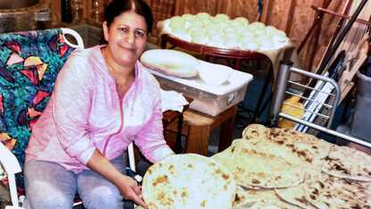 A Yazidi woman shows off a large batch of naan, a round, flat, leavened bread. In keeping with cultural traditions, many women share freshly prepared naan with their neighbors, including Americans. (Photo courtesy of Zozan Bashar)