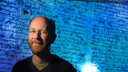 Adrian Wisnicki, assistant professor of English, stands in front of a projected image of David Livingstone's 1871 diaries.
