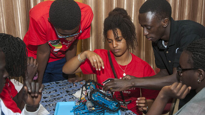 Sidy Ndao (righ) offers advice to a student team as it finishes assembling a robot at the SenEcole robotics camp in Dakar, Sengal, in March.