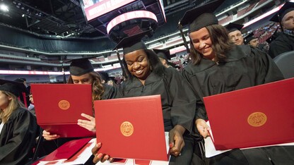 (From left) Julia Storm, Davetta Nelson and Gianna Astorino look over their diplomas in criminal justice during the summer all-university commencement ceremony Aug. 13 at Pinnacle Bank Arena.