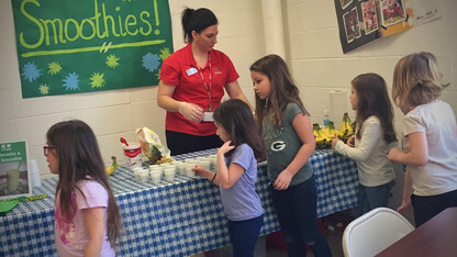 Nebraska Extension Educator Kayla Colgrove shares smoothie samples with Tri County Public Schools students during a recent farmers market at the school.