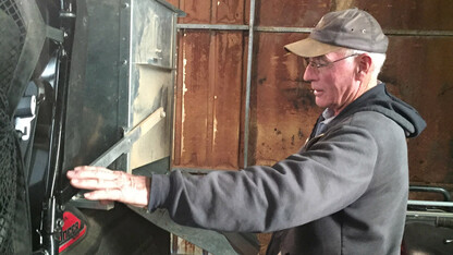 Nebraska rancher Rowan Ballagh uses assistive technology on his ranch in north-central Nebraska. AgrAbility helped with adding a specialized feeder in the back of a side-by-side utility vehicle to reduce lifting and carrying heavy bags of feed. In addition, they helped address his biggest need, his cattle chute. His manual chute required him to be standing, moving back and forth, and lifting both arms above his head, which was a challenge for him due to back pain, arthritis, weakness in his left