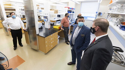 Joshua Santarpia (second from right), NSRI research director, answers a question from NU President Ted Carter (right) during a tour of the new Collaborative Biosecurity Laboratory on Sept. 27.