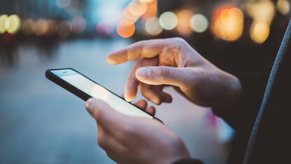 Close-up of person's hands operating smartphone