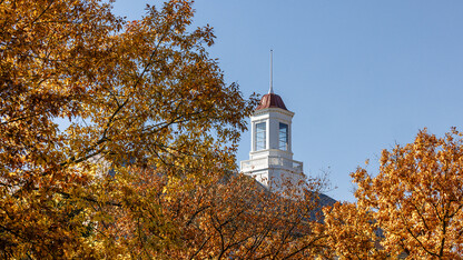 The Love Library cupola behind trees with autumn leaves